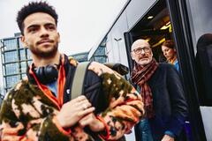 young man and older gentleman smiling walking out of train station